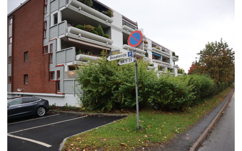 Gjesteparkering ved innkjørsel og låst beboer parkering under leilighetene.