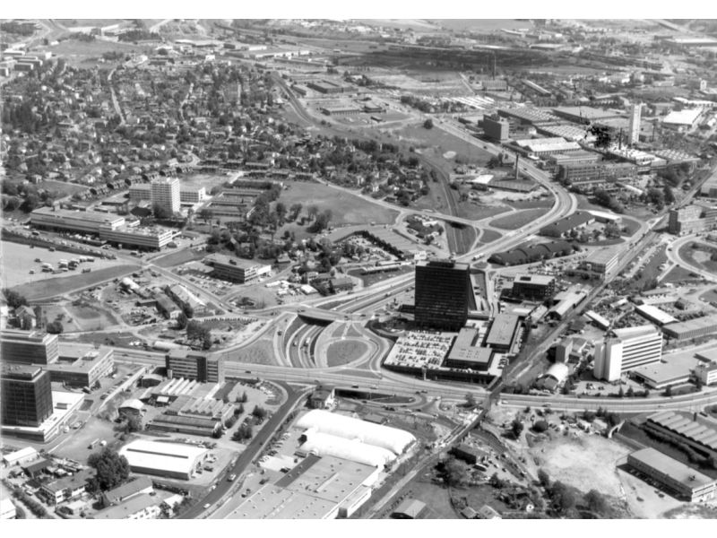 Økernsenteret 1972. Da senteret ble åpnet 2. juni 1969, var det med sine 18 etasjer Norges største forretnings- og kontorbygg og et av de høyeste byggene i Oslo. Det var et av de første kjøpesentra som ble bygget for å avlaste Oslo sentrum. Lørenporten i forkant. Foto: Fjellanger Widerøe / Oslo byarkiv